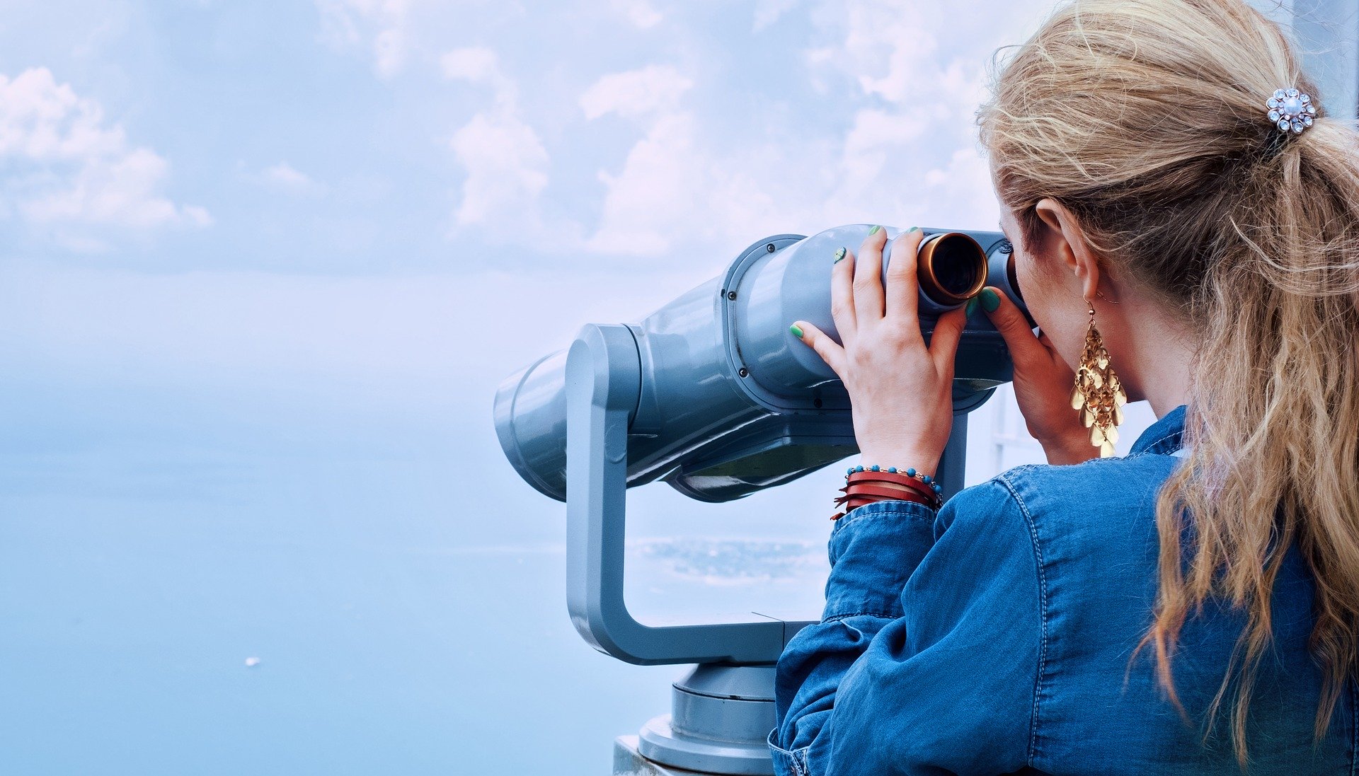 recruitment_junge_blonde__frau_mit_fernglas rekrutieren_junge_blonde_frau_mit_zopf_an_einem_fernglas